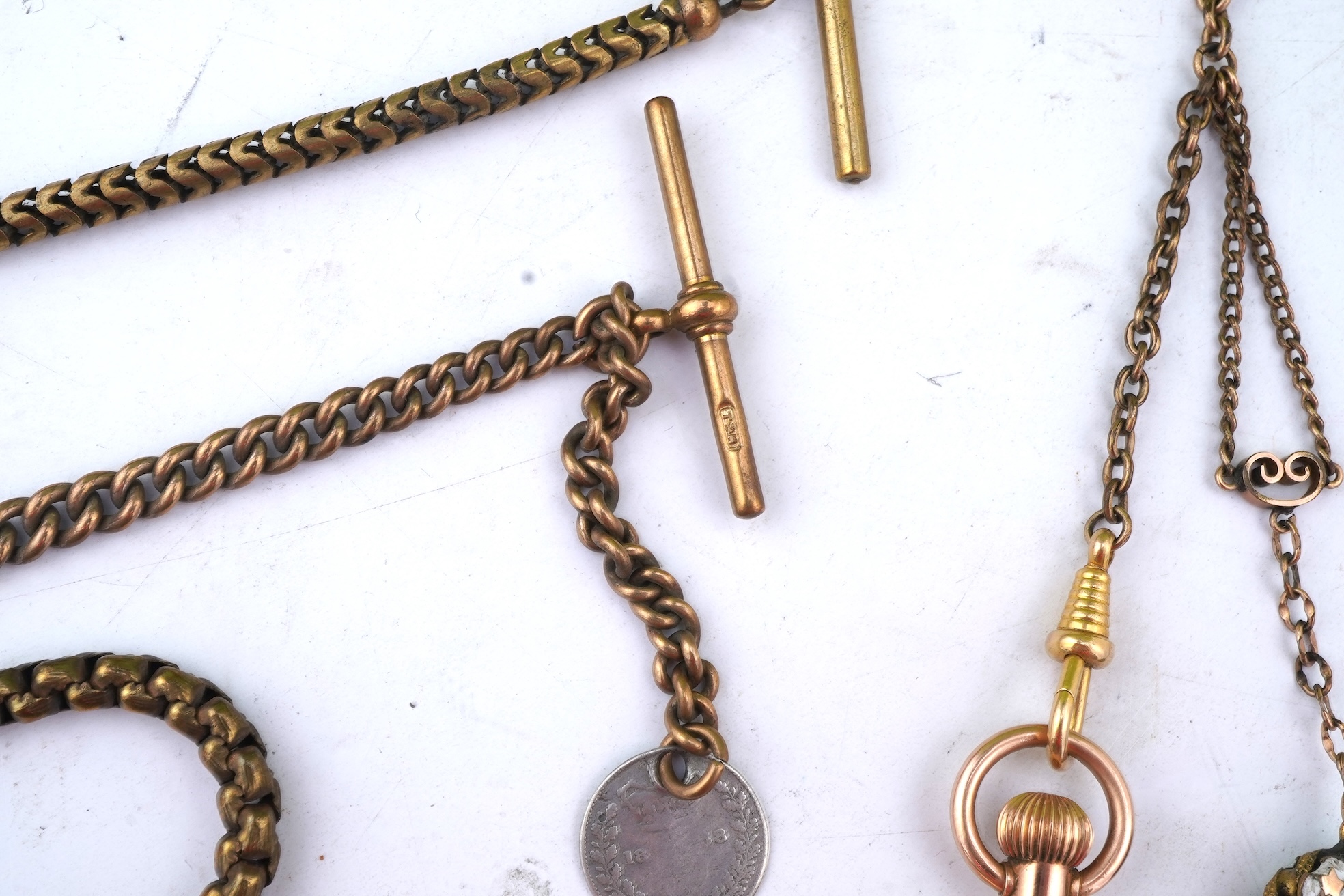 A group of gilt metal/pinchbeck jewels, 19th and early 20th century, comprising: a brooch of knotted design; two gate bracelets; a fancy link bracelet; an open-faced pocket watch; two oval panel brooches, and two watch c